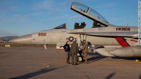 Caitlin Hillygus (left) and Nathaneal Airiyie (right) instruct Tareq Salameh before his incentive flight in front of an EA-18G Growler on February 8, 2023, at Luke Air Force Base in Glendale.