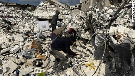 Residents of destroyed buildings use their hands to remove dirt and debris, desperately searching for their loved ones. 