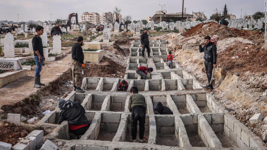People dig graves for earthquake victims in Idlib on February 13.