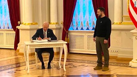 US President Joe Biden signing the guest book at the Ukrainian Presidential Palace, as Ukraine President Volodymyr Zelensky looks on.
