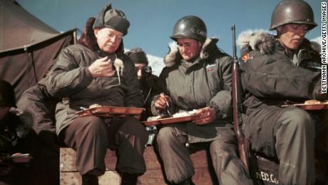 On a visit to the front lines, President Dwight D Eisenhower (1890 - 1969) eats with American soldiers in Korea, December 1952. (Photo by Bettmann via Getty Images)