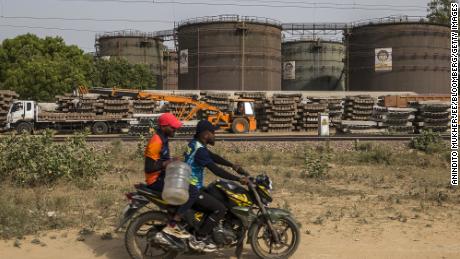A motorcyclist rides past an oil depot in New Delhi, India, on Sunday, June 12, 2022.