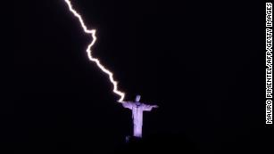 TOPSHOT - A lightning hits the hand of the Christ the Redeemer statue at the Corcovado mountain in Rio de Janeiro, Brazil, on February 21, 2023. (Photo by MAURO PIMENTEL / AFP) (Photo by MAURO PIMENTEL/AFP via Getty Images)