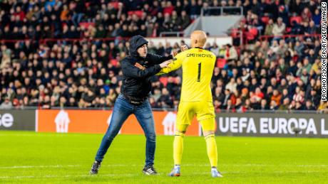 A pitch invader aimed a punch at Sevilla goalkeeper Marko Dmitrović during the game against PSV.