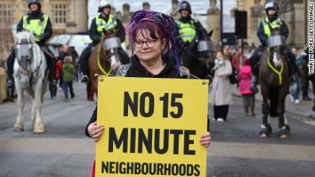 A woman holds a placard at a protest against 15-minute cities in Oxford, England on February 18, 2023.
