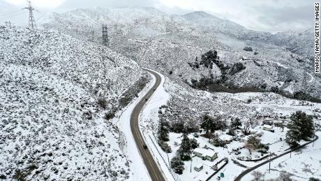 In an aerial view, drivers pass through the snow-covered Sierra Pelona Mountains in Los Angeles County. 