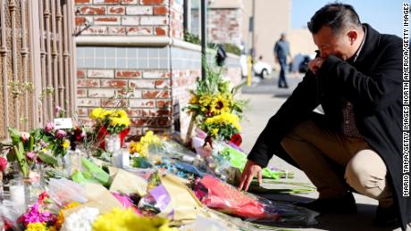 Monterey Park mayor Henry Lo kneels at a makeshift memorial outside the scene of a deadly mass shooting at a ballroom dance studio on January 23, 2023 in Monterey Park, California. 