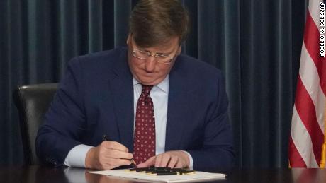 Mississippi GOP Gov. Tate Reeves signs a bill to ban gender-affirming care in the state for anyone younger than 18, during a February 28, 2023, news conference in Jackson, Mississippi.