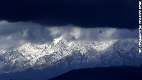 Snow-covered mountains serve as a backdrop for airplanes flying over the San Fernando Valley on Tuesday. 