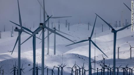Wind turbines in the southern Sierra Nevada Mountains are surrounded by fresh snow at unusually low elevations brought by a powerful storm Sunday near Mojave, California. 