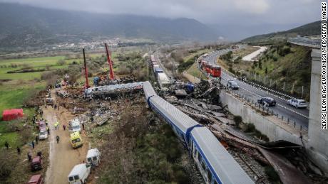 Police and emergency crews search the debris of a crushed wagon after the deadly train crash in the Tempi Valley near Larissa, Greece.