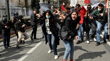 TOPSHOT - Protesters shout towards gas-throwing riot police during a massive demonstration in Athens on March 5, 2023, following the deadly train accident late on February 28. 