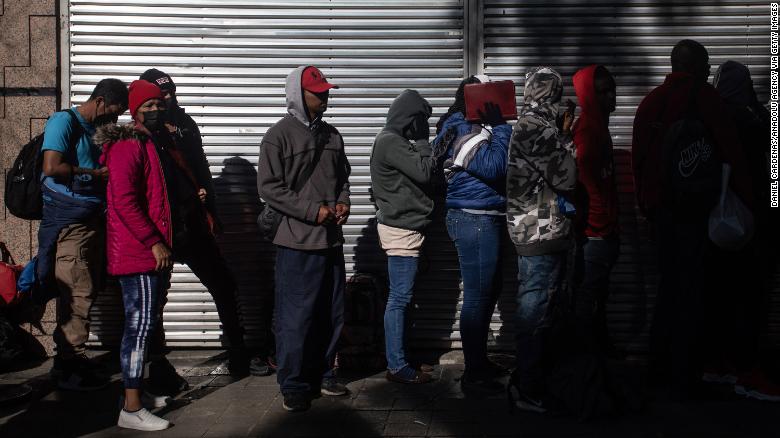 Migrants wait in line outside at the Mexican Commission for Refugee Assistance in Mexico City, Mexico, on January 24, 2023.