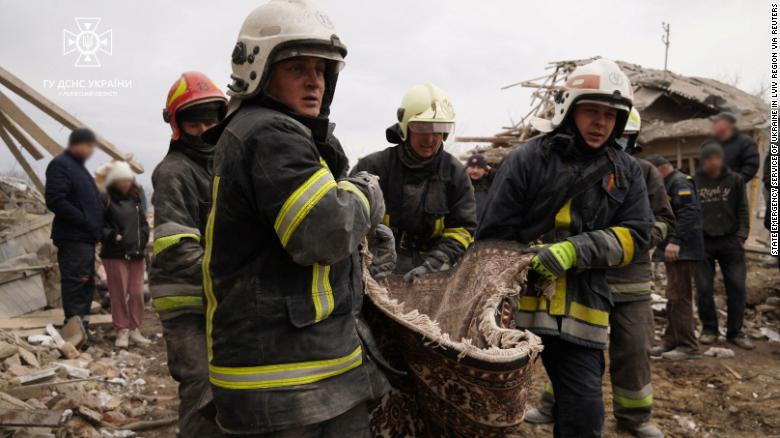 Rescuers carry a body from residential buildings destroyed by a Russian missile strike on March 9.