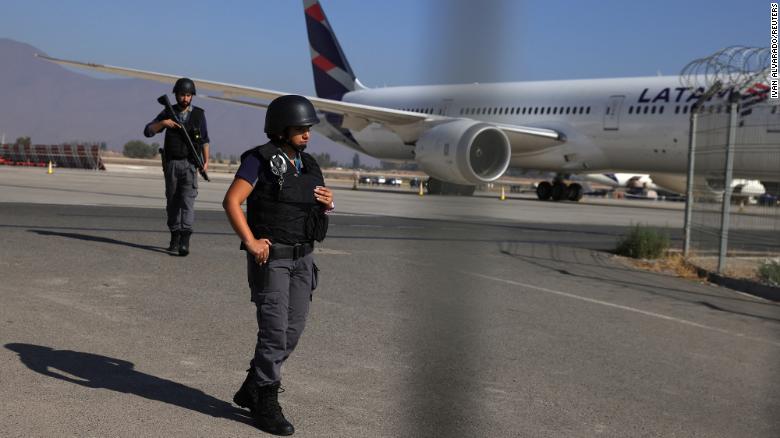 Security personnel stand guard at an access point of the airport after an attempted robbery.