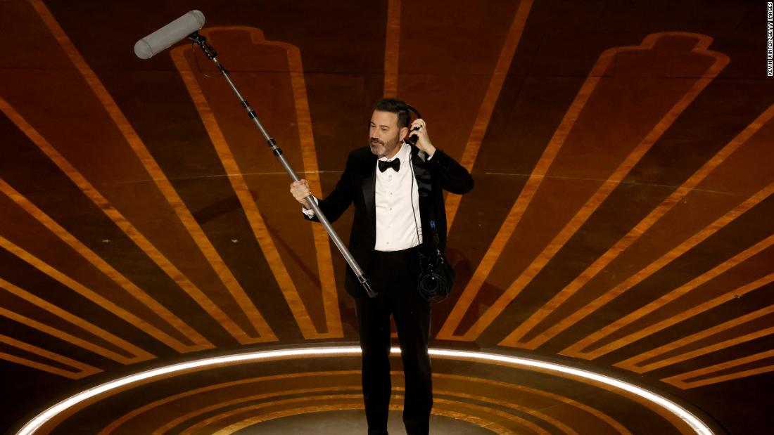 Kimmel holds a microphone on stage. He also hosted the show in 2017 and 2018.