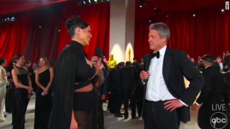 Hugh Grant&#39;s awkward Oscars red carpet interview with Ashley Graham divides opinion