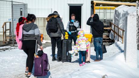 An officer speaks to migrants as they arrive at the Roxham Road border crossing in Roxham, Quebec, Canada, on March 3, 2023.