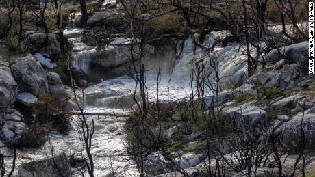Snowmelt water rushes from mountains burned in the 2021 French Fire near Wofford Heights, California, on Sunday.