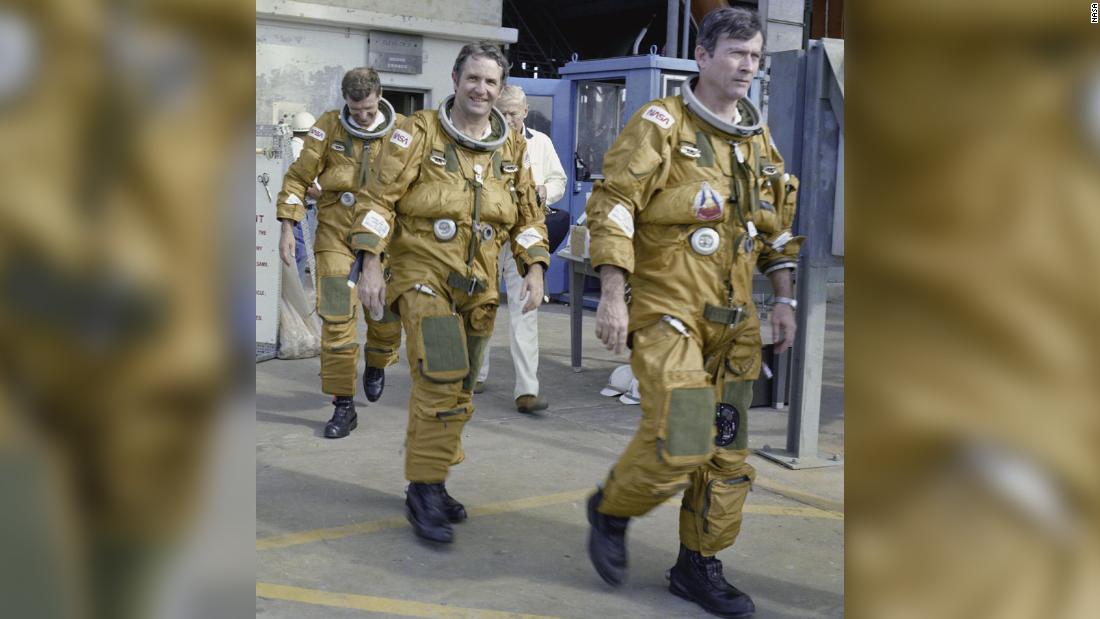Space Shuttle prime and backup astronaut crews prepare to be briefed on the use of the emergency pad escape system, known as the &quot;slidewire,&quot; in this photo from January 6, 1981. From left to right are backup astronauts Joe Engle and Richard Truly, and primary crew commander John Young. The slidewire system provided a quick and sure escape from the upper pad platforms in case of a serious emergency. 