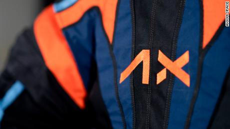Axiom Space, which holds the contract to develop spacesuits for NASA&#39;s Artemis Program, included its logo and company colors on a top cover over the spacesuits.