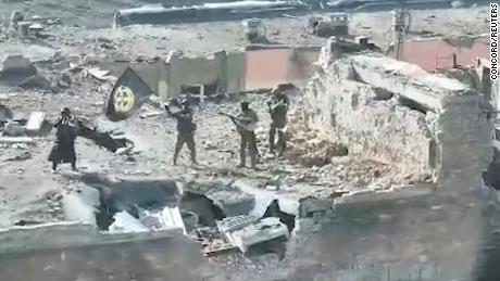 A still image taken from video released by Prigozhin&#39;s press service on March 2 shows what it said to be Wagner fighters standing with a flag on top of a building in Bakhmut.