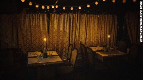 Candles light an empty restaurant during a power cut in downtown Kyiv, December 2022. 