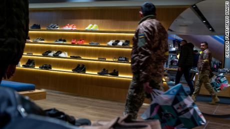 A soldier shops in a Kyiv mall, in December 2022. As the war grinds on, Ukraine&#39;s economy continues to suffer.  