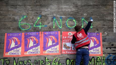 An anti-pension reform demonstrator writes &quot;64-non&quot; on part of a roadblock to the the oil terminals at the Total Energies refinery during a protest in Donges, western France on Friday. 