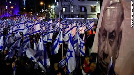 Demonstrators hold Israeli flags next to an image of Prime Minister Benjamin Netanyahu in Tel Aviv, Israel, on Saturday.