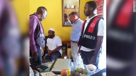 The NYPD&#39;s Thomas Galati, second from right, oversees the arrest of Abdullah el-Faisal, seated, in Jamaica in 2017. 