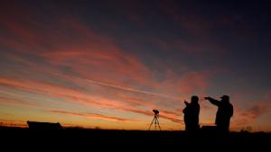People are silhouetted against the sky at dusk as they watch the alignment of Saturn and Jupiter, Monday, Dec. 21, 2020, in Edgerton, Kan. The two planets are in their closest observable alignment since 1226. Appearing a tenth of a degree apart, the alignment known as the &quot;great conjunction&quot; has also been called the &quot;Christmas Star.&quot; (AP Photo/Charlie Riedel)