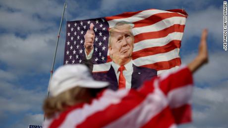 Evelyn Knapp walks past a flag featuring former President Donald Trump that supporters are flying near his Mar-a-Lago home on March 20, 2023 in Palm Beach, Florida.