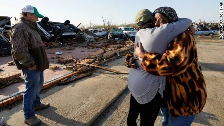 Tracy Hardin, center, who with her husband Tim, left, own Chuck&#39;s Dairy Bar, consoles a neighbor in Rolling Fork, Mississippi.