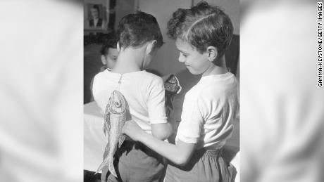 Two brothers sticking April Fools&#39; Day fish on each other&#39;s backs on April 1, 1963. 