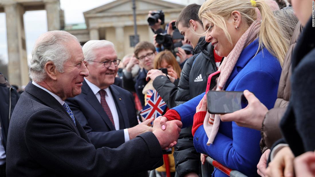 The King shakes hands with well-wishers at Brandenburg Gate.