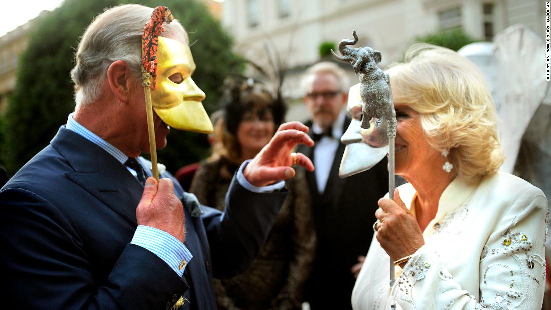 Charles and Camilla pose with masks as they host a charity reception in London in July 2013.