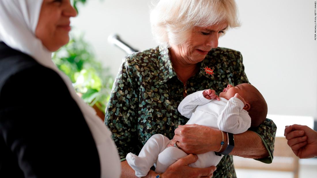 Camilla holds a baby girl while attending a Women of the World Foundation event in Amman, Jordan, in November 2021.