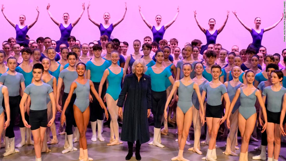 Camilla stands on stage with students during a visit to the Elmhurst Ballet School in Birmingham, England, in March 2023.