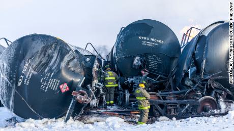 Firefighters work near piled up train cars, near Raymond, Minn., Thursday, March 30, 2023, the morning after a BNSF freight train derailed. Authorities say a train hauling ethanol and corn syrup derailed and caught fire and residents within 1/2 mile of the crash were ordered to evacuate from their homes. 