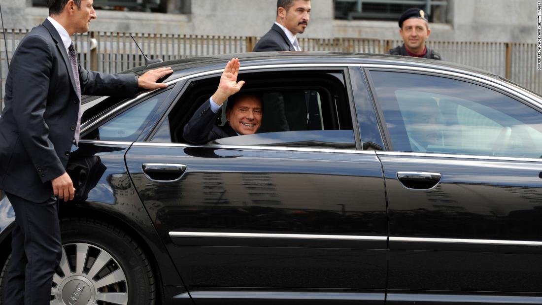 Berlusconi waves as he leaves a court in Milan in September 2011.