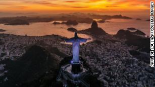 TOPSHOT - The sun rises in front of the Christ the Redeemer in Rio de Janeiro, Brazil on March 29, 2023. (Photo by CARL DE SOUZA / AFP) (Photo by CARL DE SOUZA/AFP via Getty Images)
