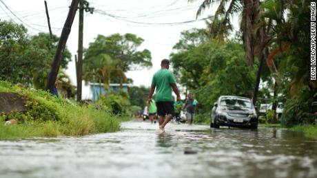 Residents wade through flooded streets in Fiji&#39;s capital city of Suva in December 2020 as Cylone Yasa approached.