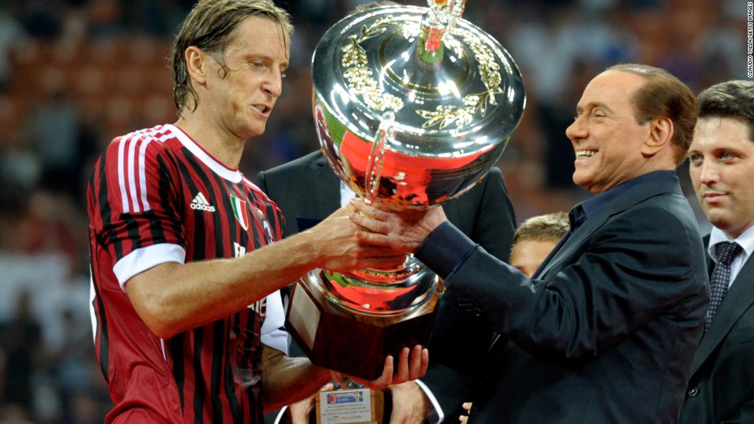 Berlusconi hands the Berlusconi Trophy to AC Milan&#39;s Massimo Ambrosini in August 2011. The trophy is awarded annually to the winner of a friendly football match in Milan.