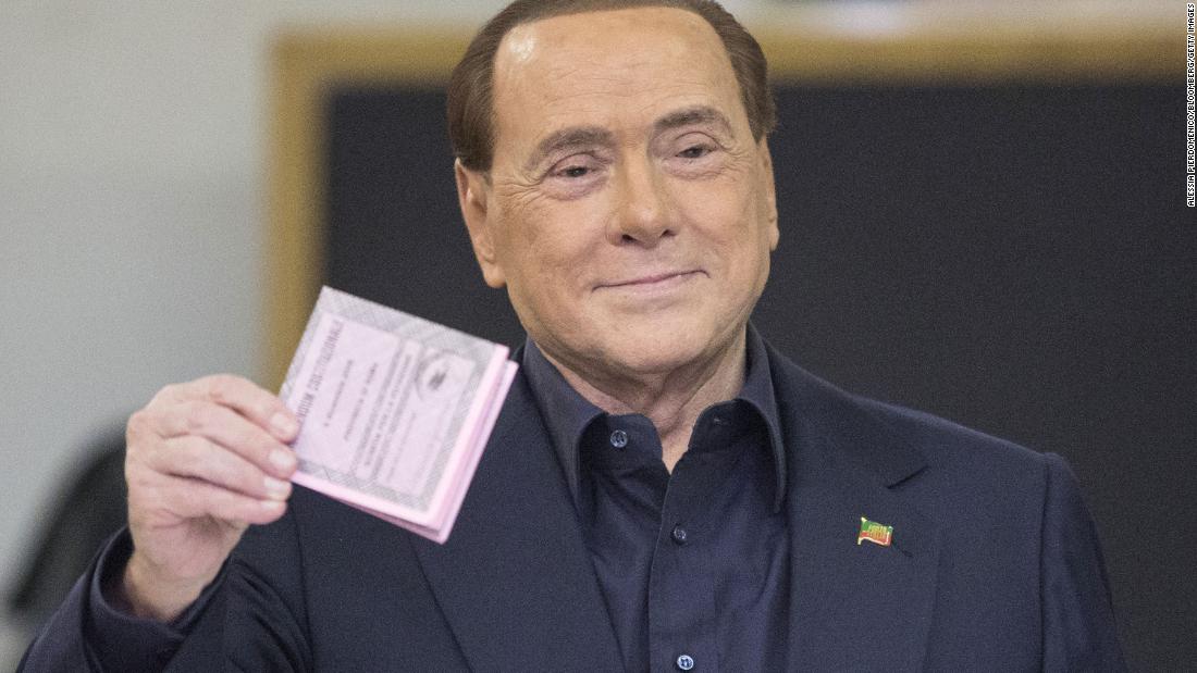 Berlusconi holds his ballot before casting his vote in the referendum on constitutional reform in December 2016.