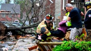 Firefighters carry a woman out of her condo after her complex was damaged by a tornado, Friday, March 31, 2023 in Little Rock, Ark. A monster storm system tore through the South and Midwest on Friday, spawning tornadoes that shredded homes and shopping centers, overturned vehicles and uprooted trees as people raced for shelter.