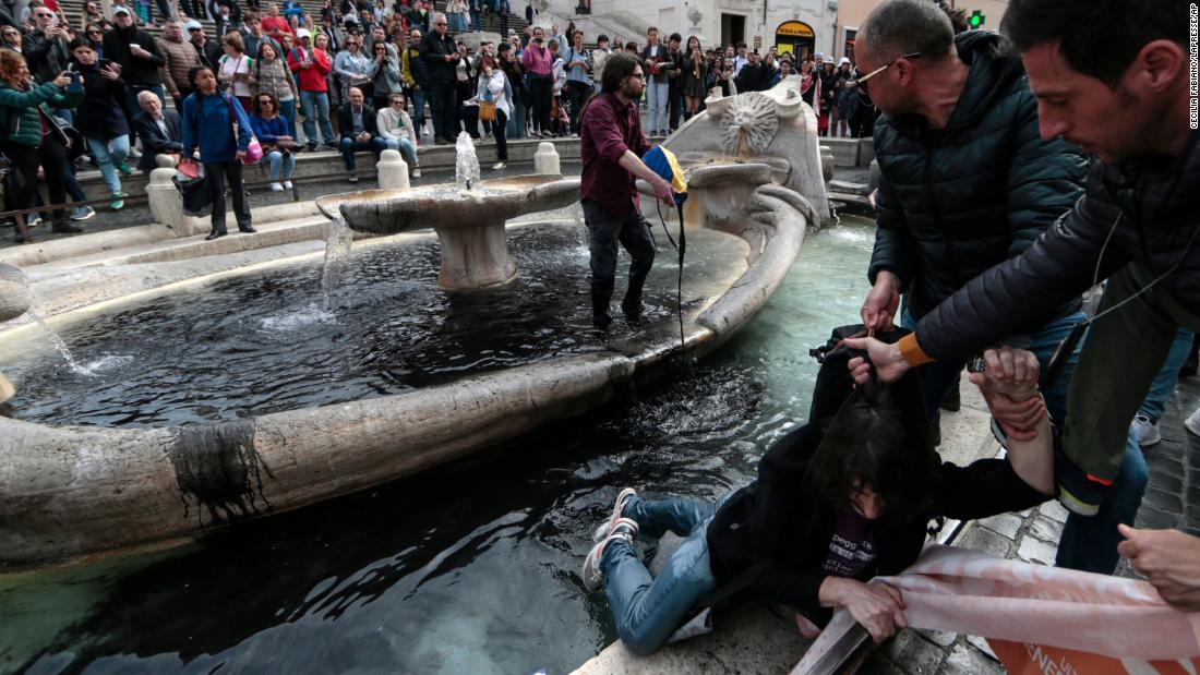 Climate activists pour black liquid into popular Italian fountain