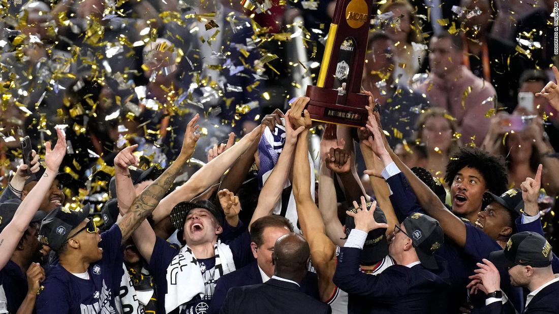 UConn players lift the championship trophy.