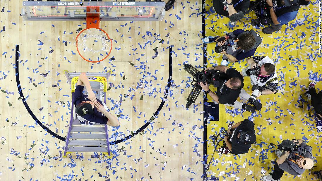 UConn&#39;s Andrew Hurley helps cut down the nets after the game. Hurley is also the son of UConn head coach Dan Hurley.