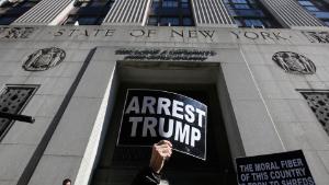 Anti-Trump demonstrators hold placards outside the Manhattan District Attorney&#39;s office in New York City on March 20, 2023.